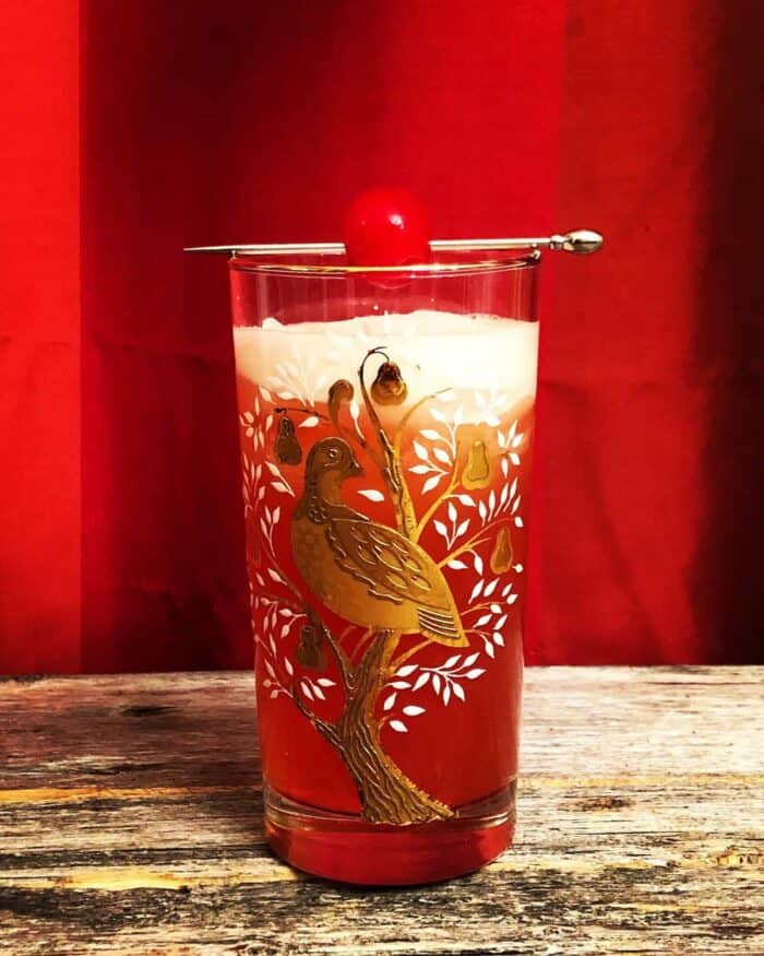 Singapore Sling in a vintage partridge in a pear tree glasses garnish with cherry on pick