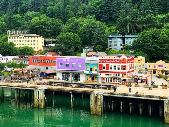 Juneau port with colorful establishments and tall trees background