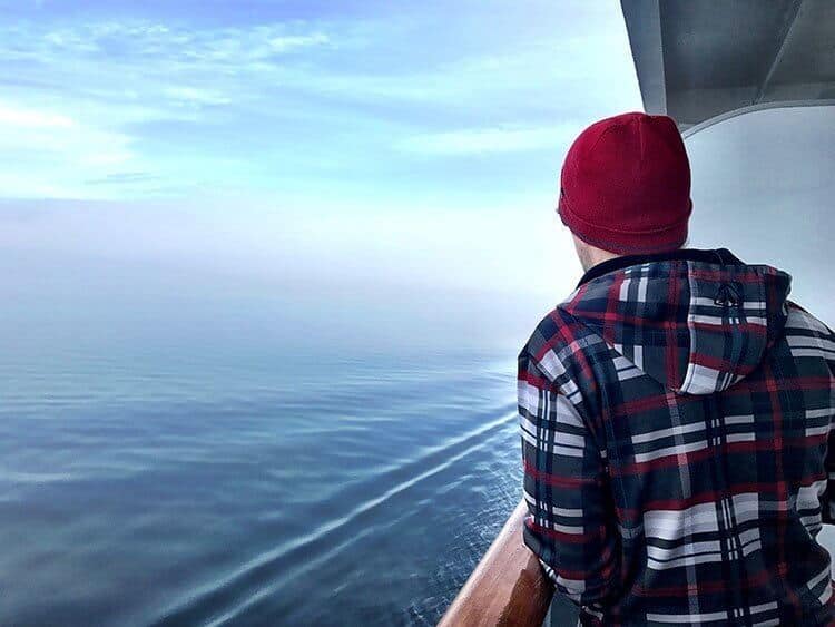 man standing outside on the deck of the ship