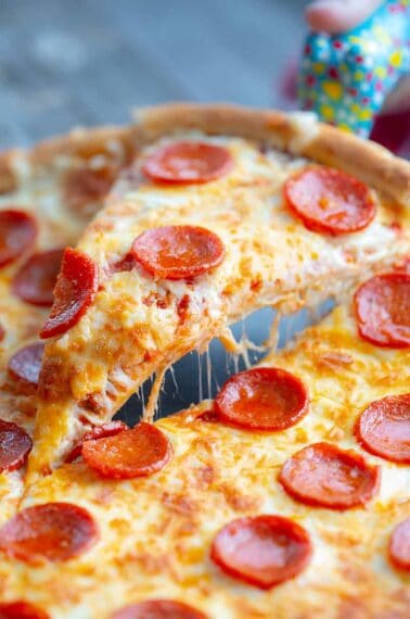 close up slice of simple pizza crust stuffed with cheese and pepperoni