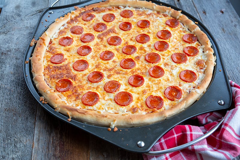 simple pizza crust stuffed with cheese and pepperoni in a large pizza pan
