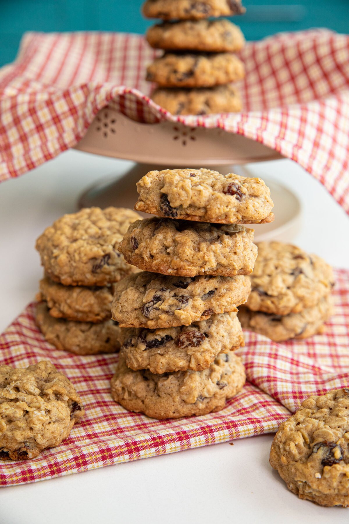 vanishing oatmeal cookies in a stack on a checkered red and white cloth napkin. 