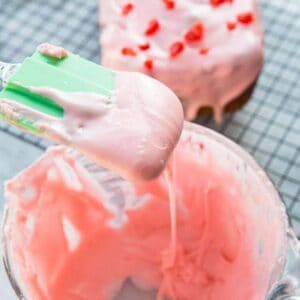 Close up Cherry Icing Glaze in a Pyrex measuring cup with green spatula