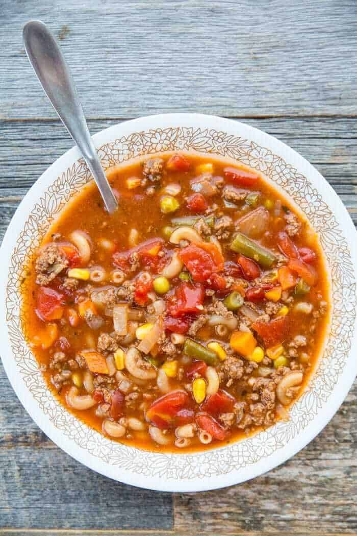 Top down shot of Hamburger Soup with Elbow Macaroni and Vegetables in a Soup Bowl with a Spoon in It
