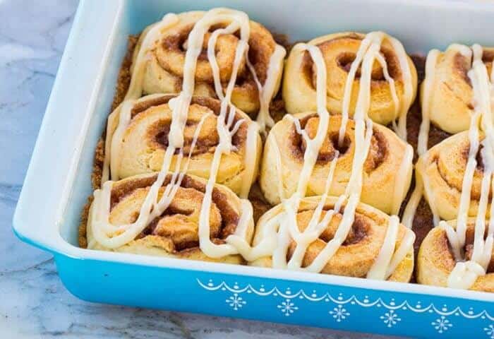 Fluffy No Rise Cinnamon Rolls with Glaze in a Blue Pyrex Baking Pan
