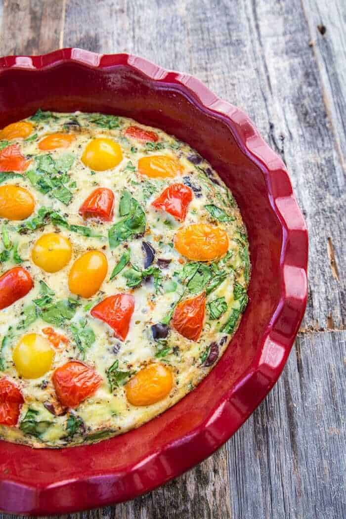 Close up of Mediterranean Vegetable Frittata in Red Bowl on Wood background