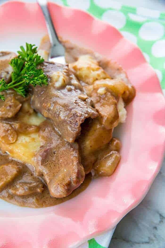 close up Crockpot Cube Steak & Gravy on pink plate