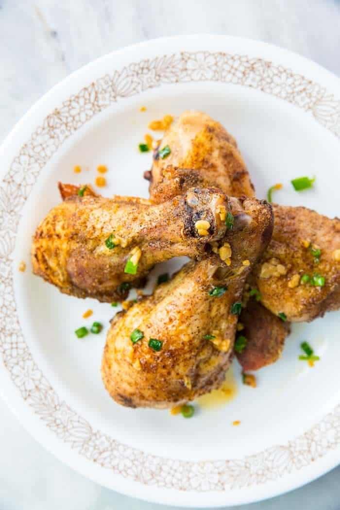 Top down shot of Plate with Baked Chicken Legs with Salt & Pepper and garlic oil on top