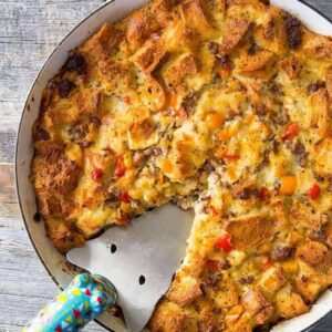 close up Sausage & Peppers Overnight Breakfast Strata in a pan on wood background