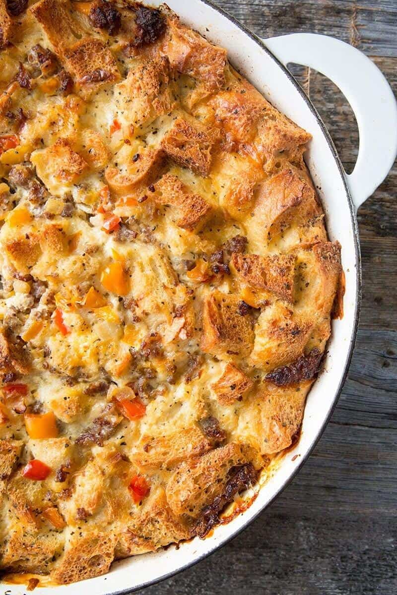 close up Sausage & Peppers Overnight Breakfast Strata in a pan on wood background