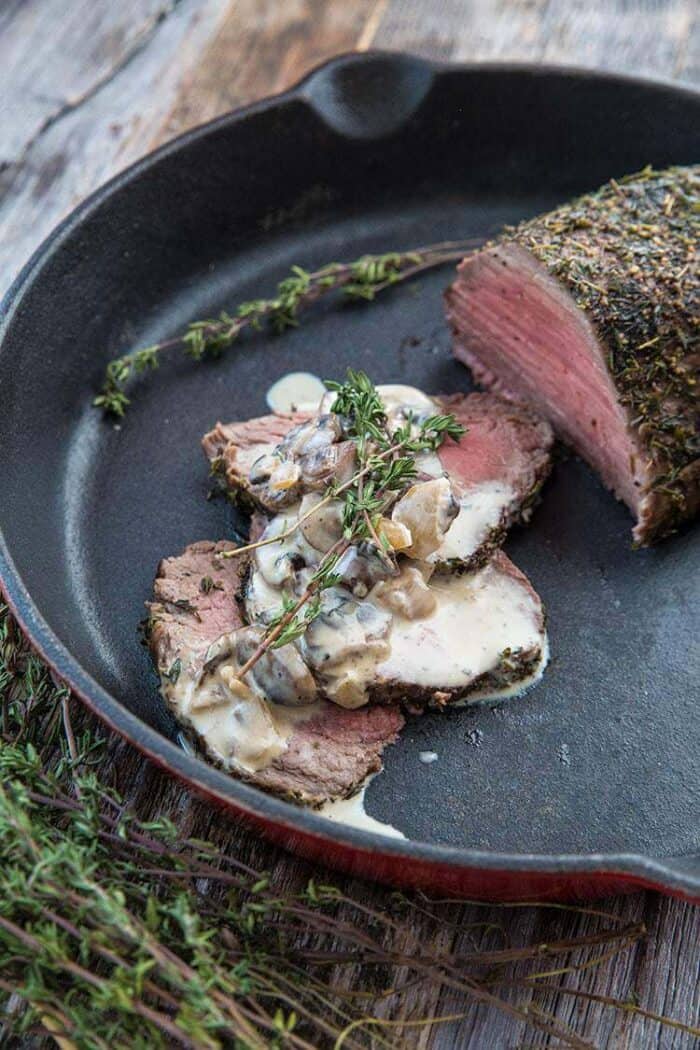 Sliced Tenderloin Roast au Poivre & Mushroom in Red Skillet with Cognac Mushroom Sauce