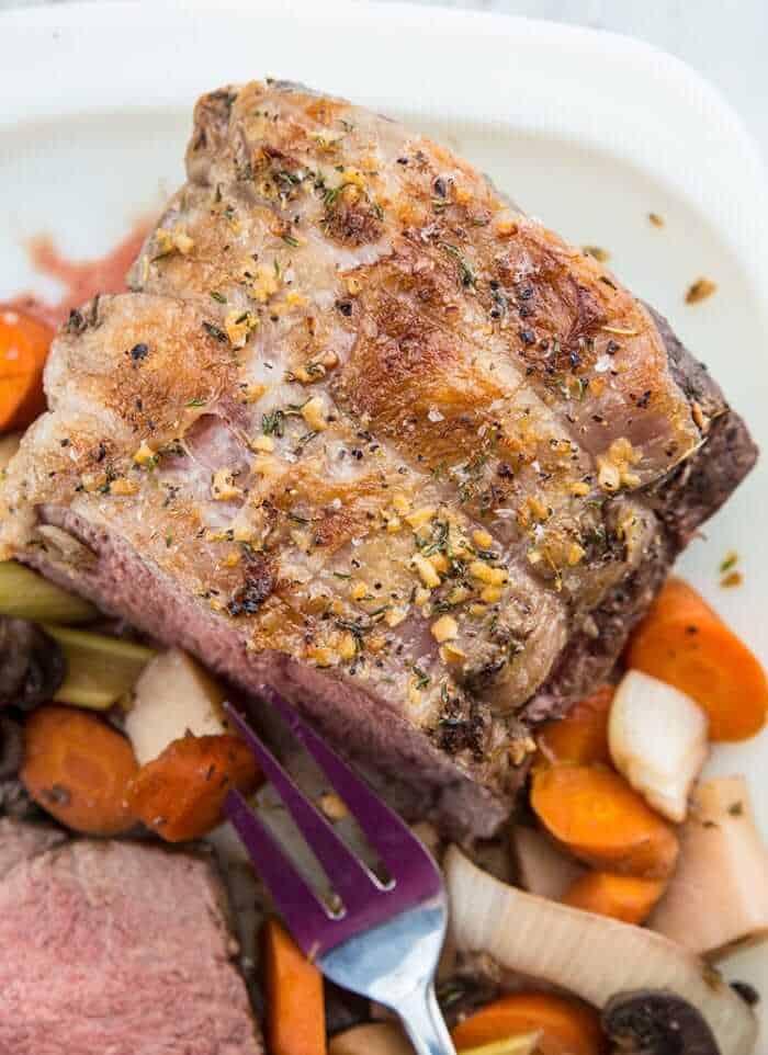 Top down Sliced Slow Cooker Striploin Roast Beef Served with Vegetables and Gravy