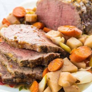 Close up of Sliced Slow Cooker Red Wine Striploin Roast Beef Served with Vegetables and Gravy