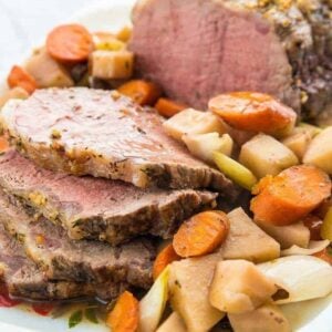 Close up of Sliced Slow Cooker Red Wine Striploin Roast Beef Served with Vegetables and Gravy