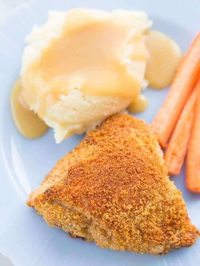a piece of Crispy Oven Baked Chicken Thigh served with a scoop of mashed potato with gravy