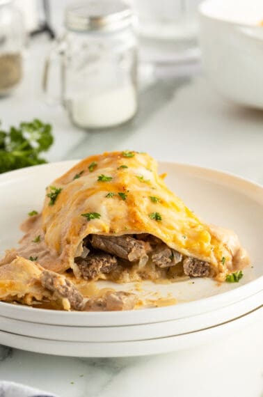 sour cream steak enchilada on a plate sliced showing the streak inside