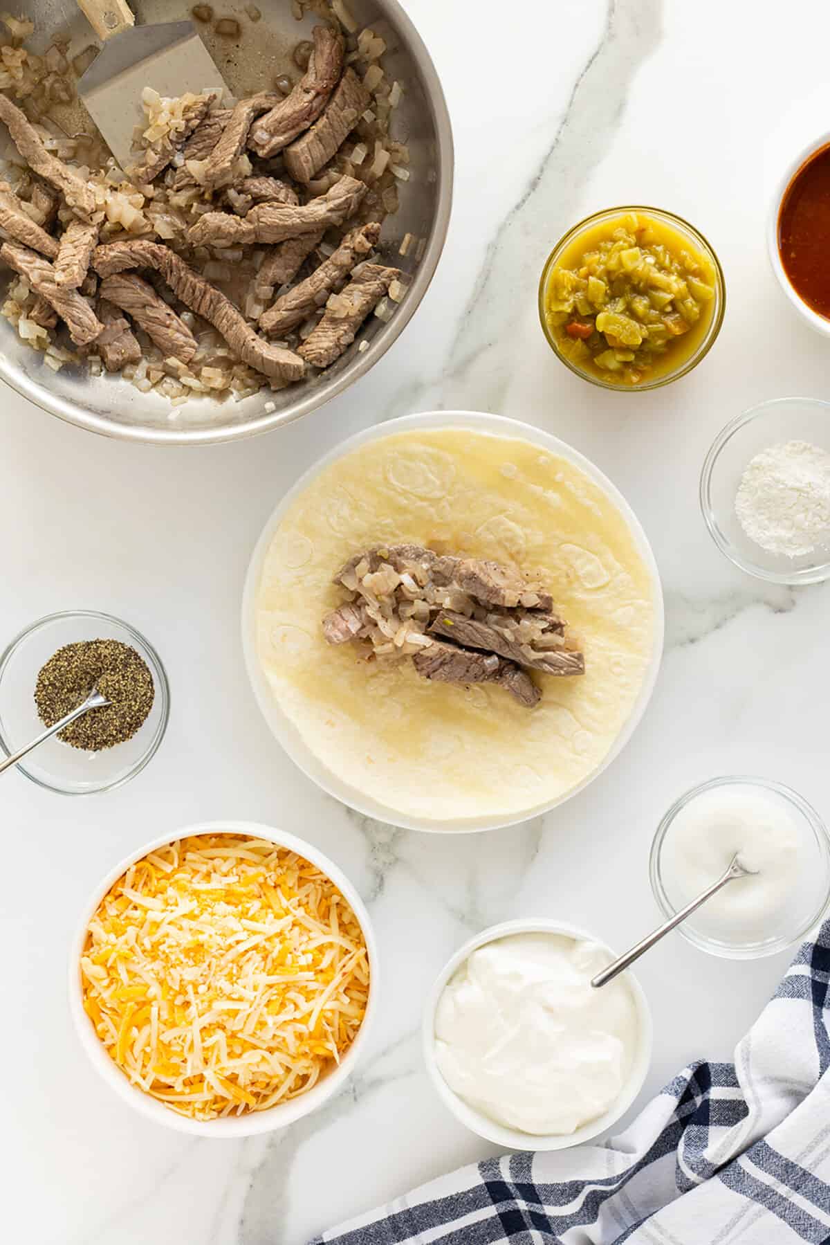 sour cream steak enchiladas steak in tortilla being prepared