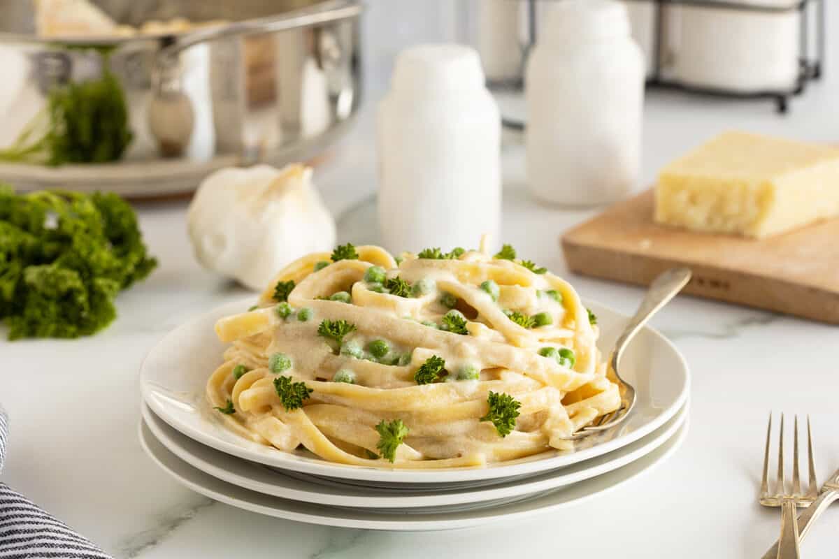 5 ingredient cream cheese Alfredo sauce on a stack of white plates