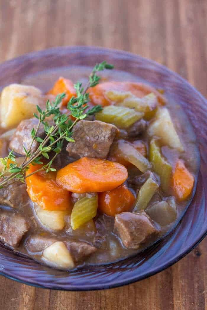 close up Beef Stew with Red Wine and fresh thyme in Purple bowl