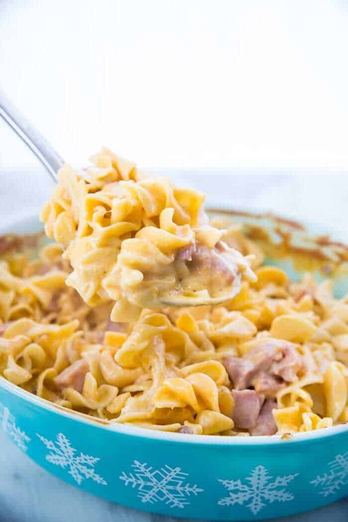 Ham & Noodle Casserole being spooned out of a casserole dish