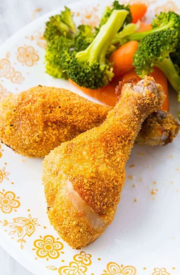 Crispy Oven Baked Chicken Legs  in a Corelle Butterfly Gold Plate garnish with vegetables