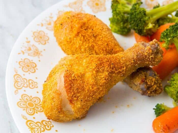Crispy Oven Baked Chicken Legs in a Corelle Butterfly Gold Plate garnish with vegetables