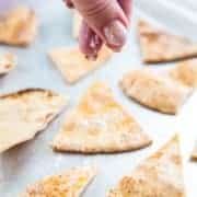 Homemade Pita Chips Being Sprinkled With Flaked Sea Salt