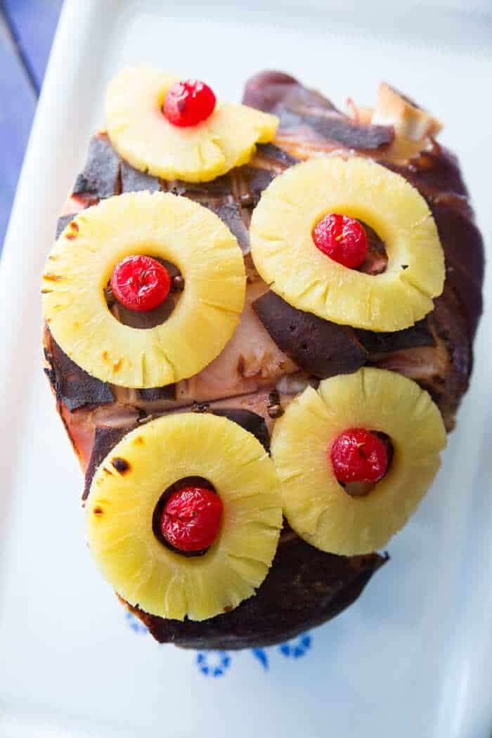close up Slow Cooker Ham on a vintage Corelle Serving Platter with pineapple rings and cherries on top