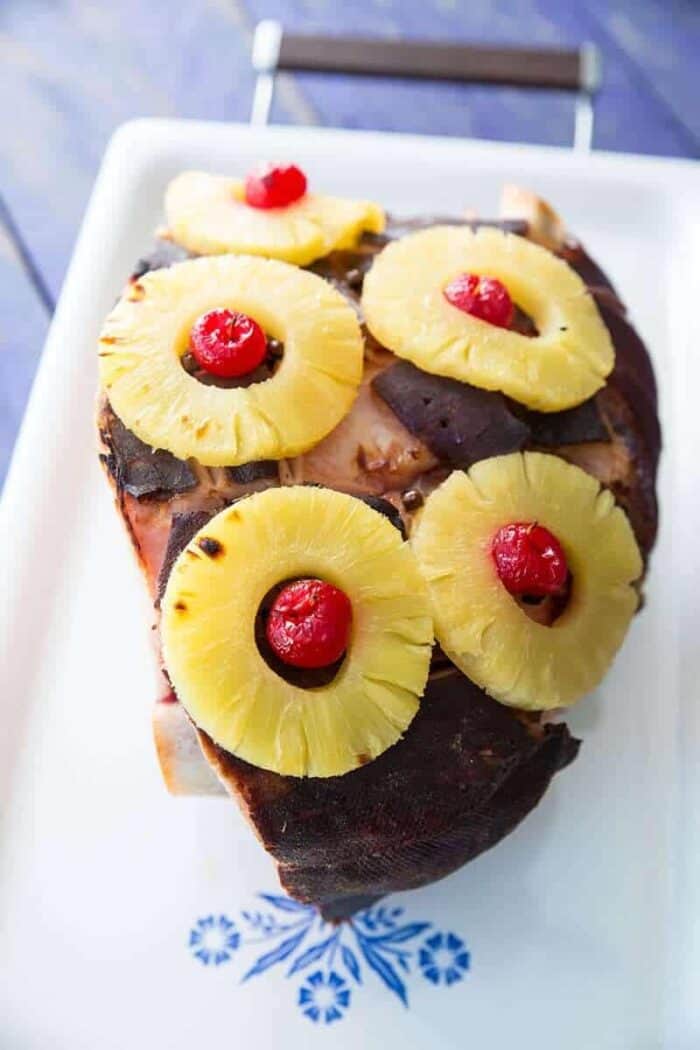 Slow Cooker Ham on a vintage Corelle Serving Platter with pineapple rings and cherries on top