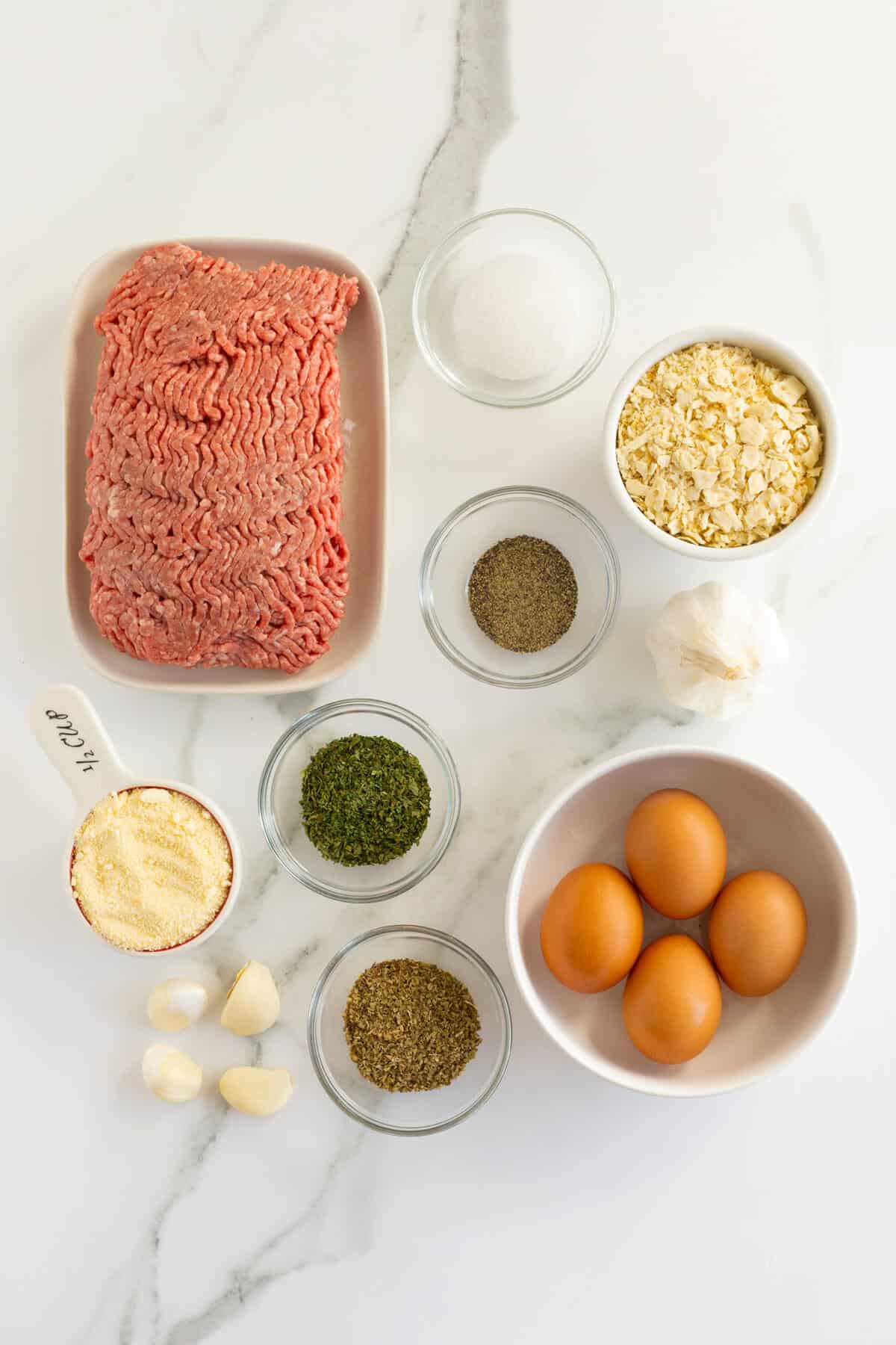 homemade meatballs ingredients in small clear and white bowls