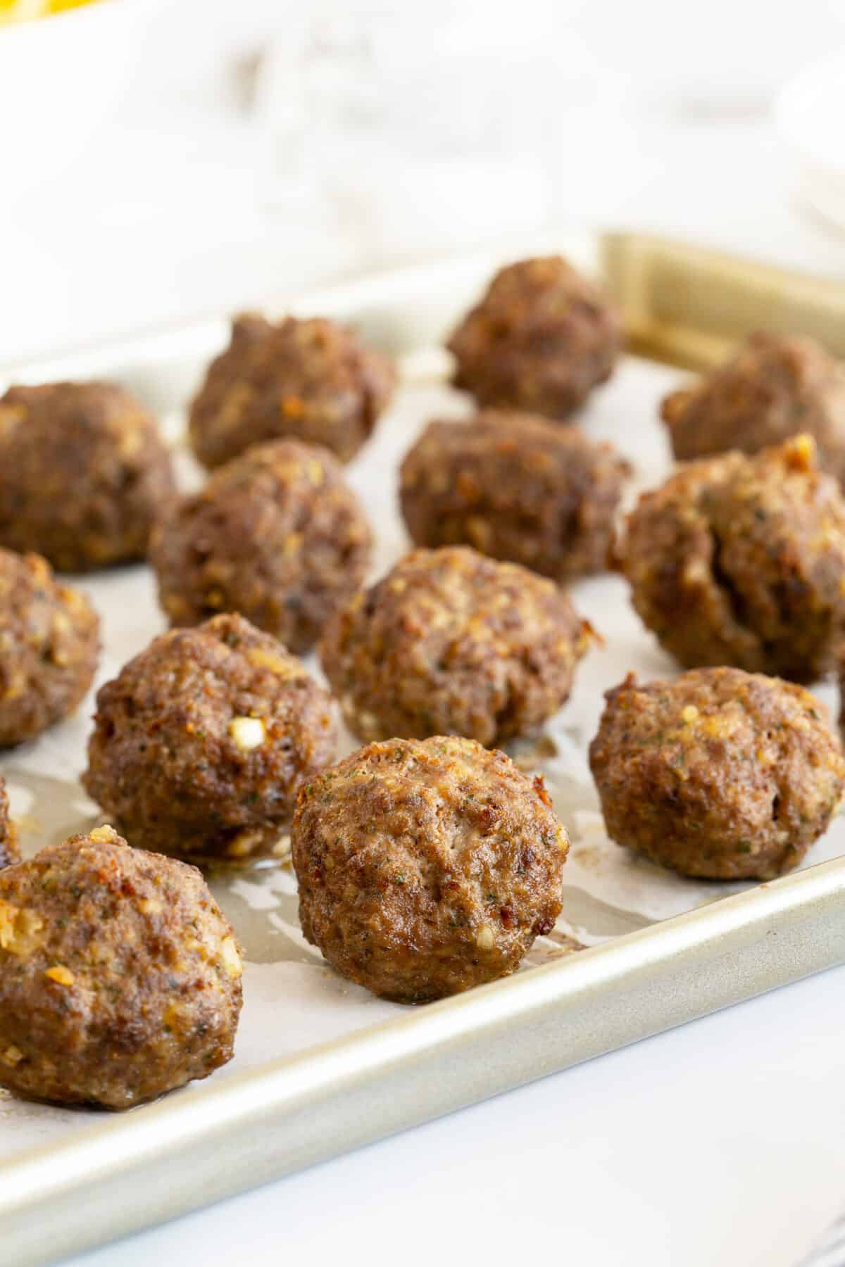 cooked homemade meatballs on a baking pan