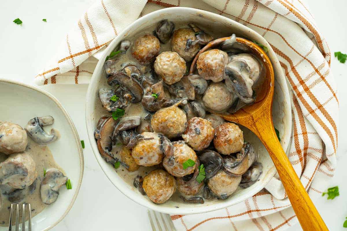 Meatballs with Homemade Mushroom Sauce on a plate with wooden spoon