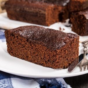 slices of Old Fashioned Gingerbread on white plates with fork and bread knife