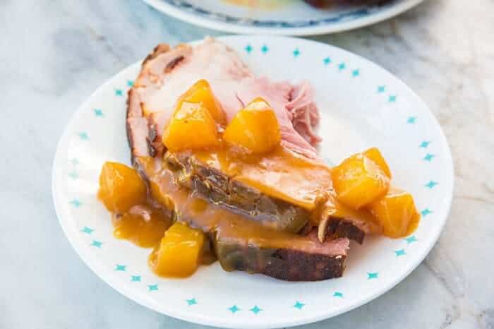 A slice of Rum Ham with pineapple tidbits in a white plate