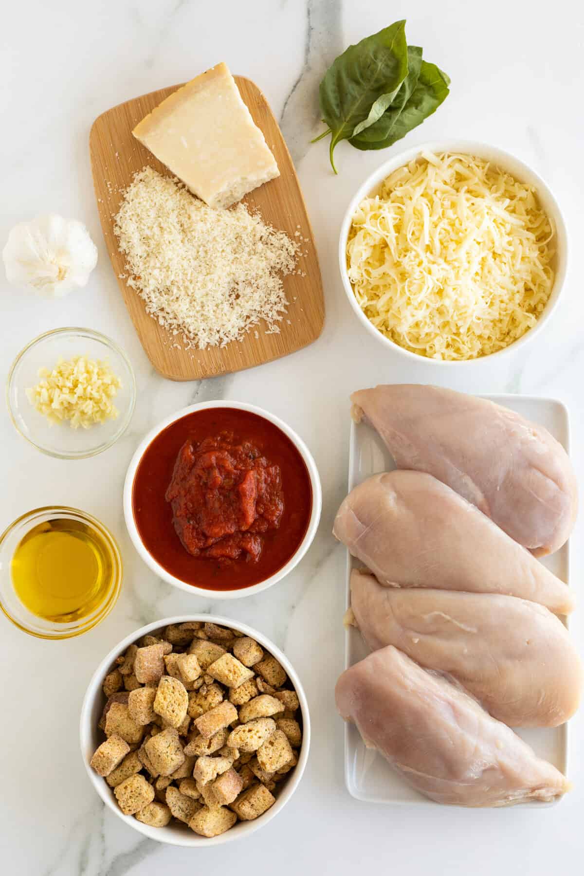 Chicken Parmesan Casserole ingredients in small white bowls