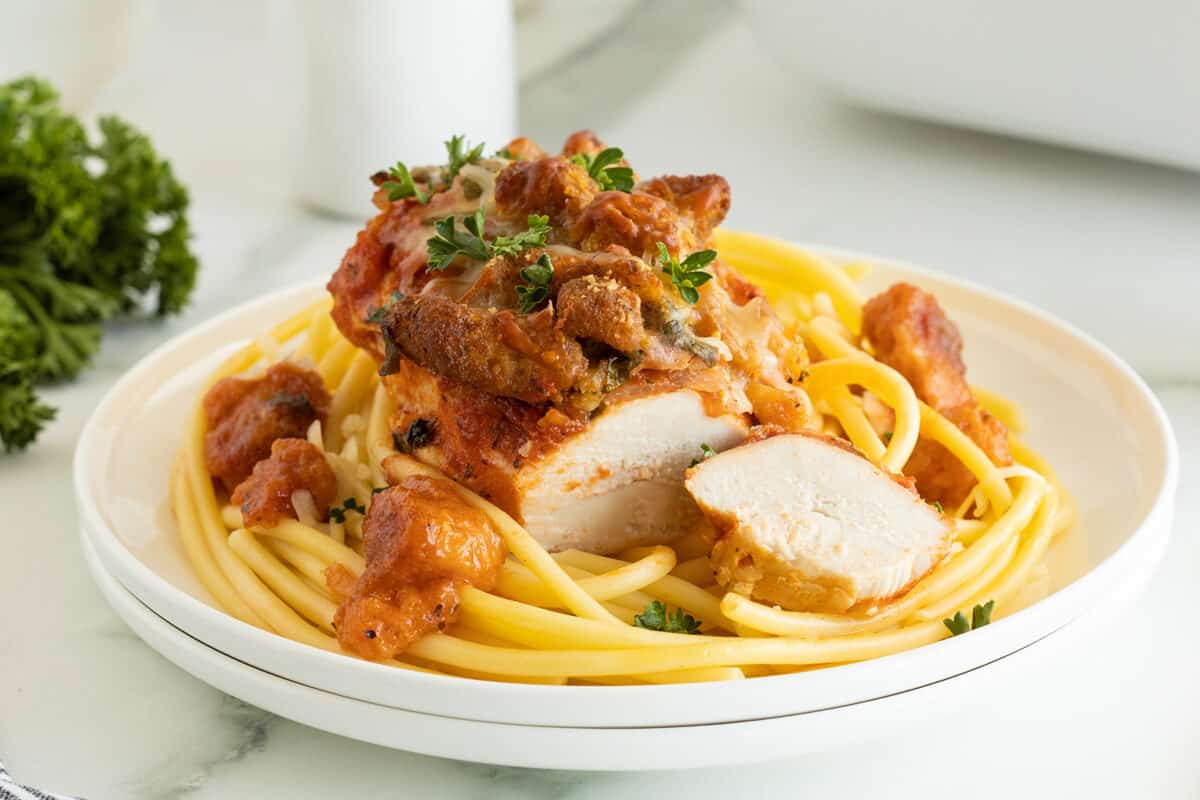 Chicken Parmesan Casserole on pasta on a white plate