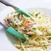 Dishing up homemade coleslaw with turquoise tongs