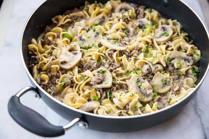 Ground Beef Stroganoff in a black skillet on marble table 