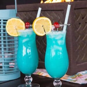 Close up of Two Blue Lagoon Cocktails with lemon slice and cherry