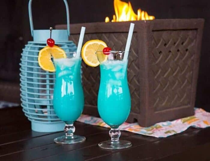 Two Blue Lagoon Cocktails with lemon slice and cherry