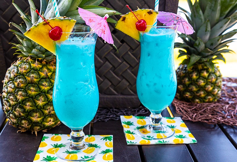 Blue Hawaiian Cocktail in a Hurricane Glass with a slice of pineapple