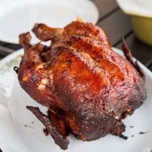 barbecue rotisserie chicken on a white platter