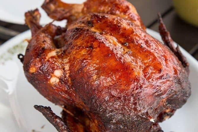 barbecue rotisserie chicken on a white platter