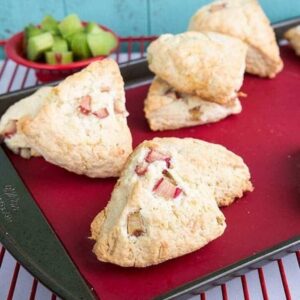 Close up of Coconut Rhubarb Scones on a red lined baking sheet