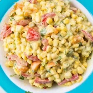 Top down shot of Corn Salad with Green Chile Dressing in a blue Pyrex Bowl