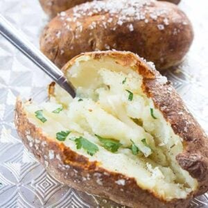 Close up of potato being scooped out by spoon on baking sheet