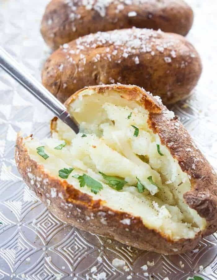 Close up of potato being scooped out by spoon on baking sheet