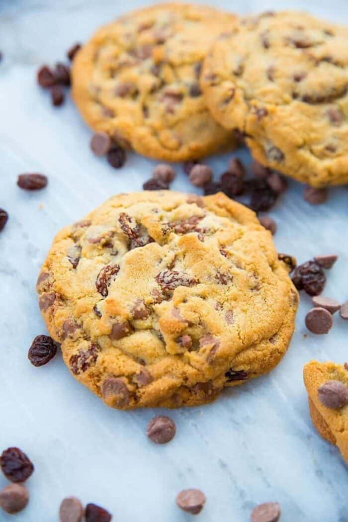 Close up of Milk Chocolate Chip Cookies with Raisins on white marble slab