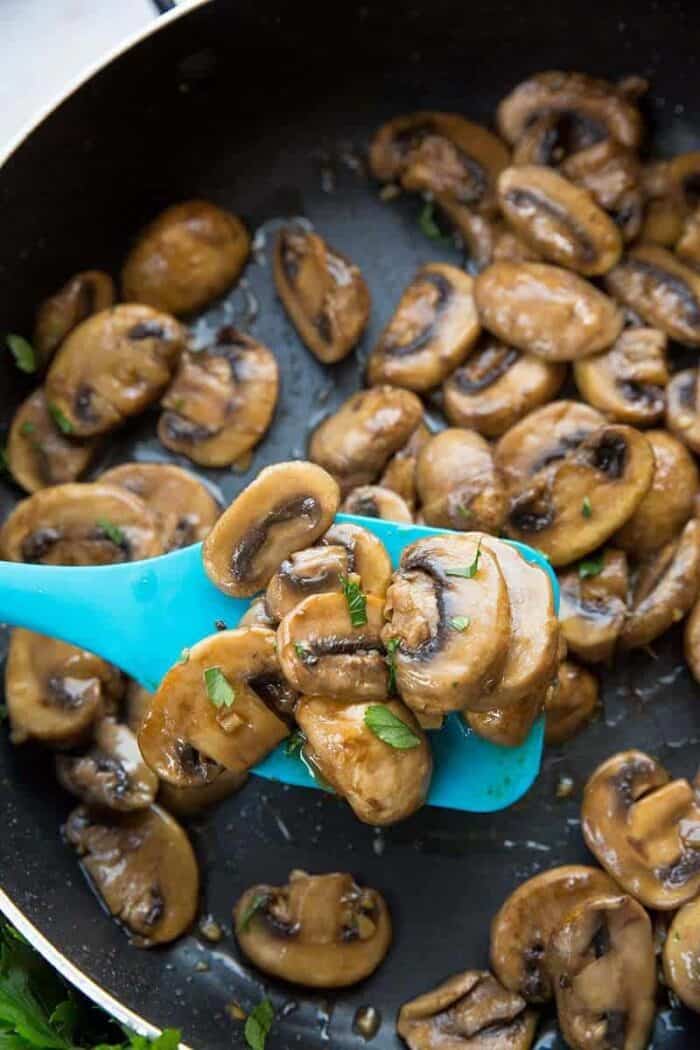 Frying the mushrooms in a large skillet with melted butter