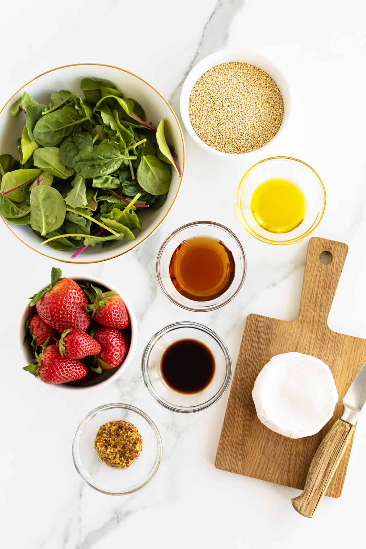 strawberry quinoa salad ingredients in small clear bowls
